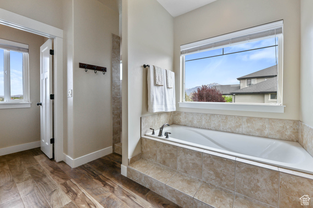 Bathroom featuring a bath and wood finished floors