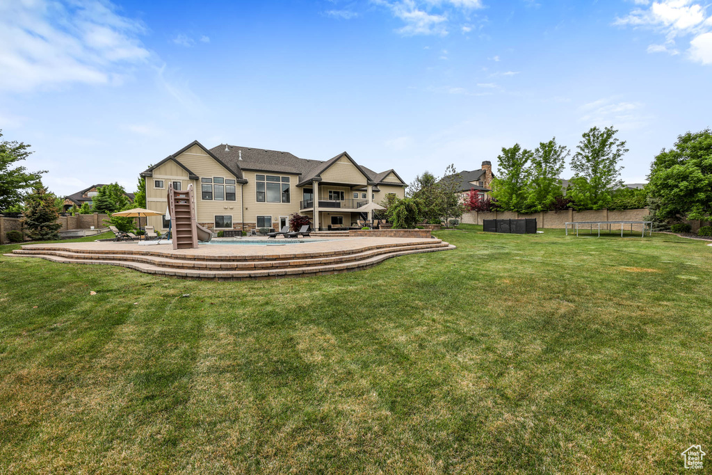Back of property featuring a trampoline and stairway