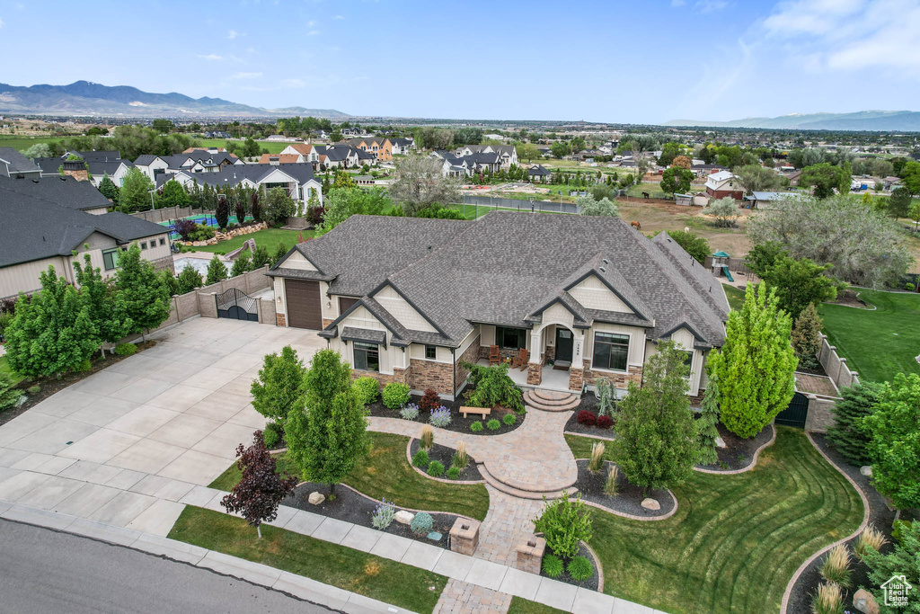 View of front facade featuring driveway, an attached garage, a shingled roof, and a mountain view