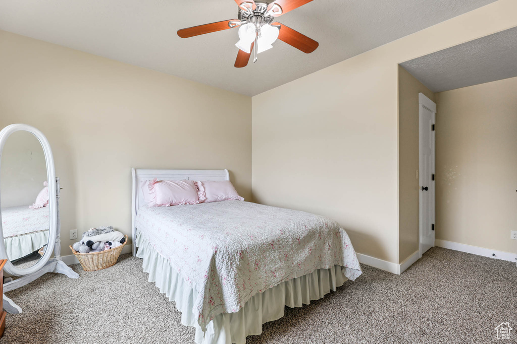 Carpeted bedroom with baseboards and ceiling fan