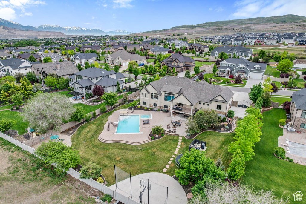 Aerial view of residential area featuring a pool and a mountain backdrop