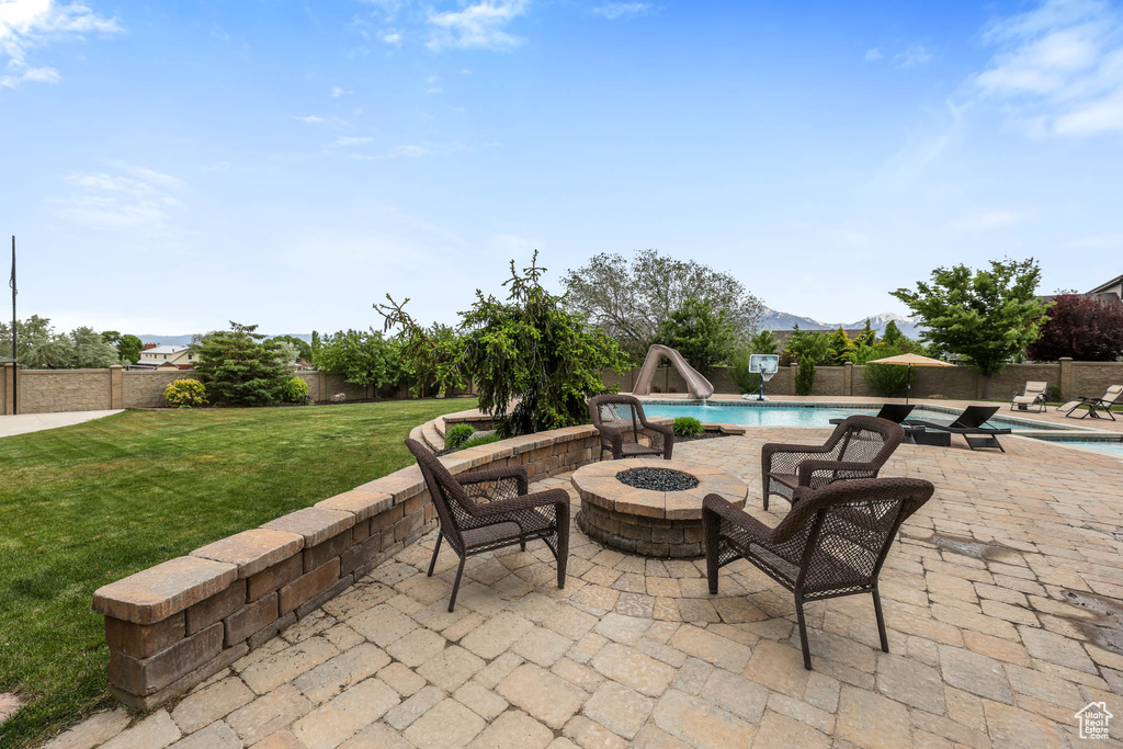 View of patio with a fire pit and a mountain view
