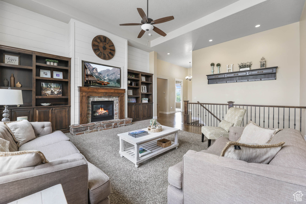 Living area featuring a ceiling fan, a stone fireplace, and recessed lighting