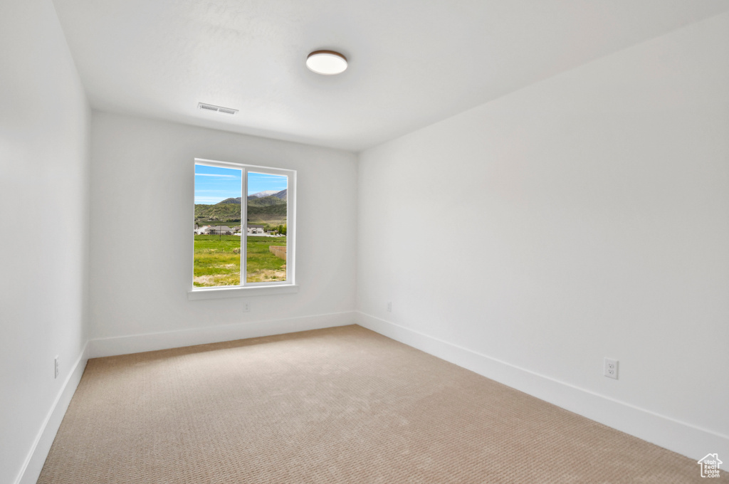 Unfurnished room featuring light colored carpet and baseboards