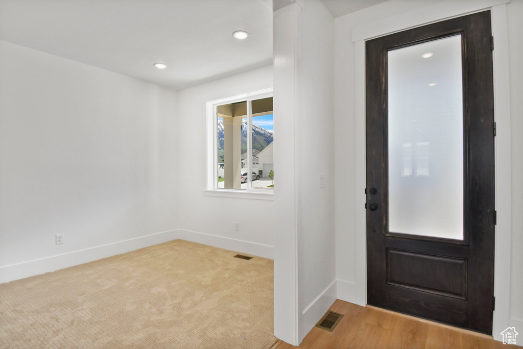 Foyer featuring baseboards, recessed lighting, and light colored carpet