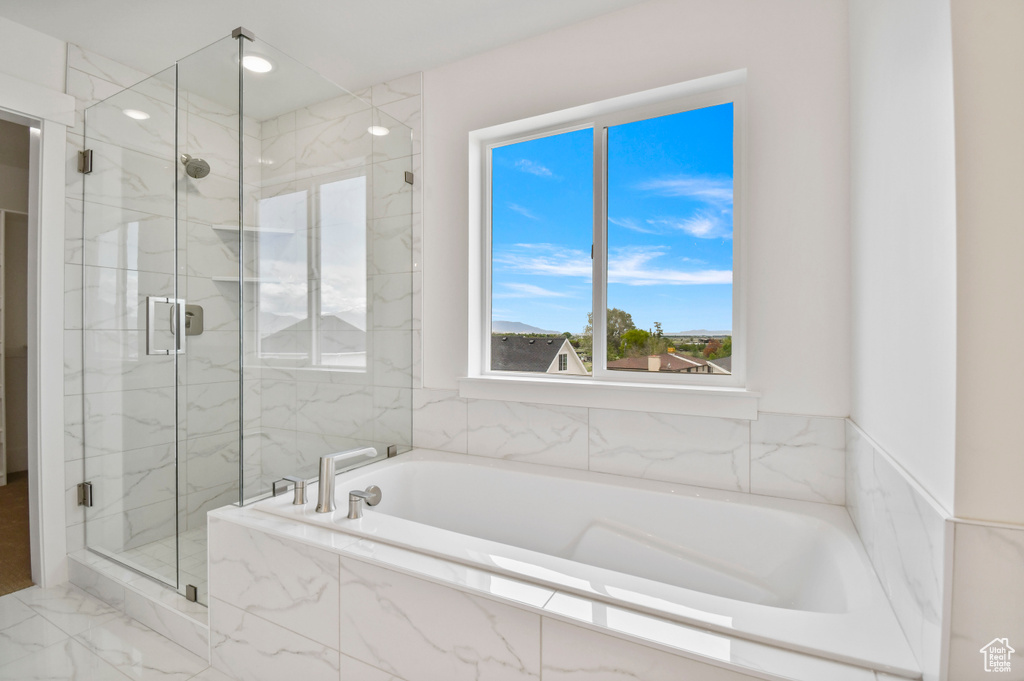 Bathroom featuring a marble finish shower, a garden tub, and marble finish flooring