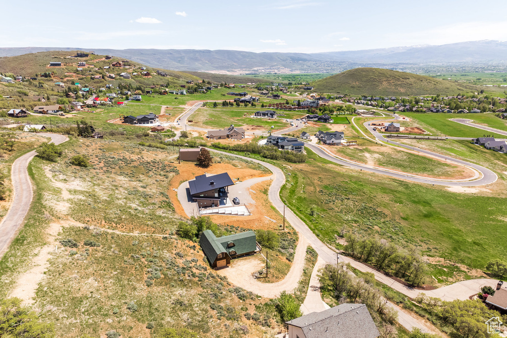 Aerial view of property and surrounding area featuring a mountainous background