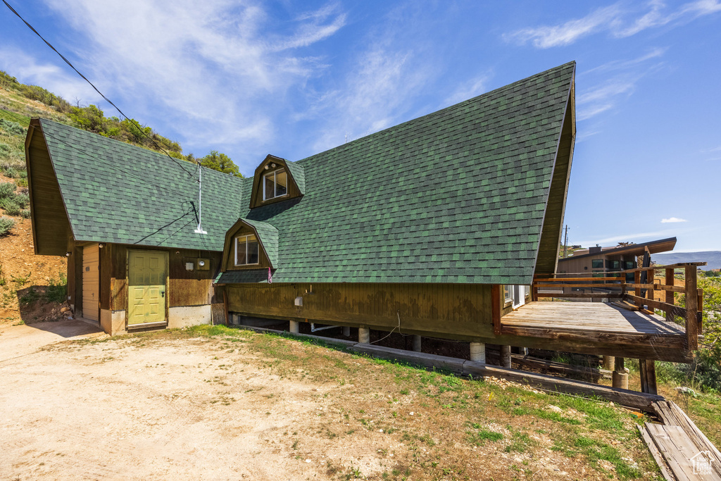 View of side of home with roof with shingles