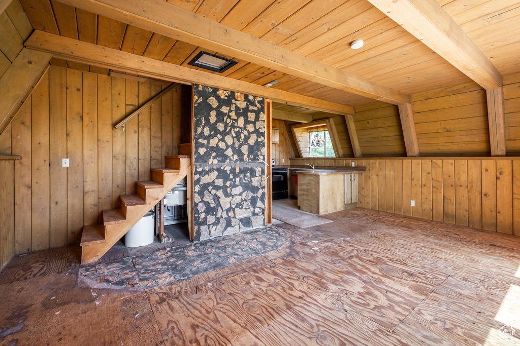 Interior space featuring wood ceiling with exposed beams and wood walls