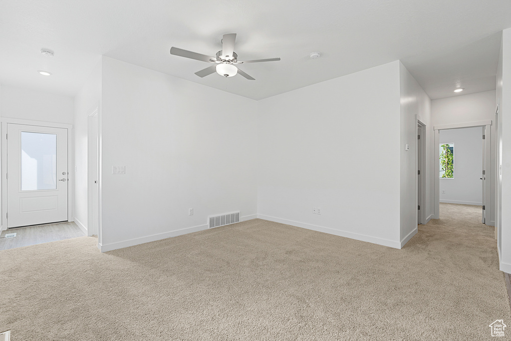 Unfurnished room featuring light carpet, a ceiling fan, baseboards, and recessed lighting