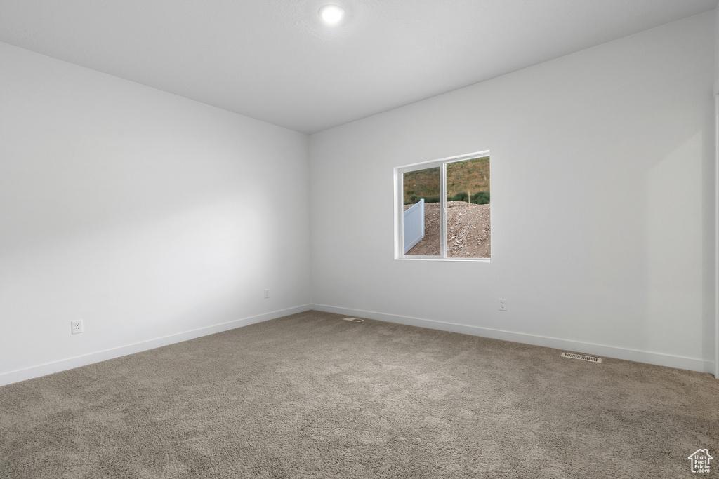 Carpeted empty room with baseboards