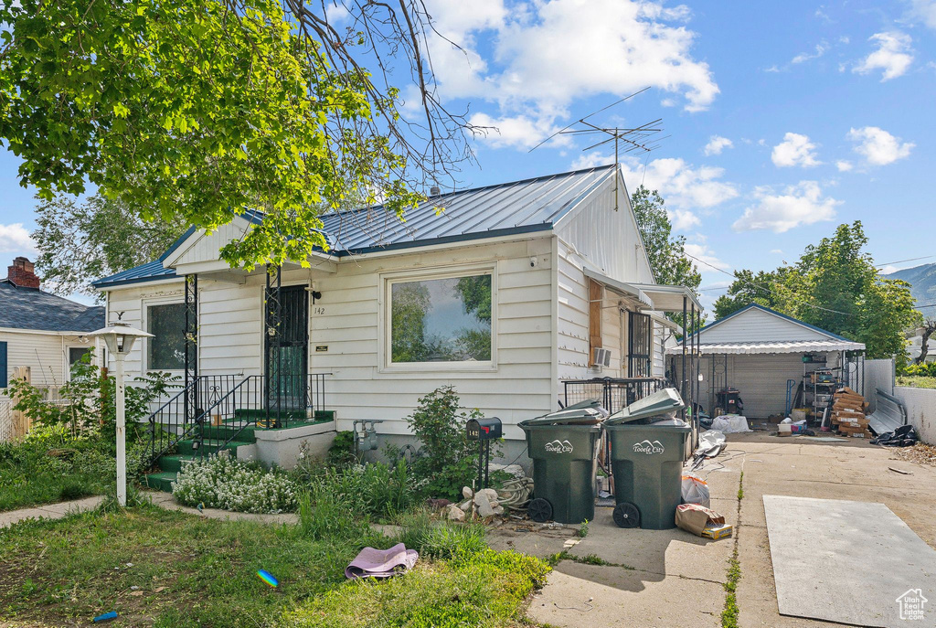 View of front of house with a standing seam roof, metal roof, and a detached garage