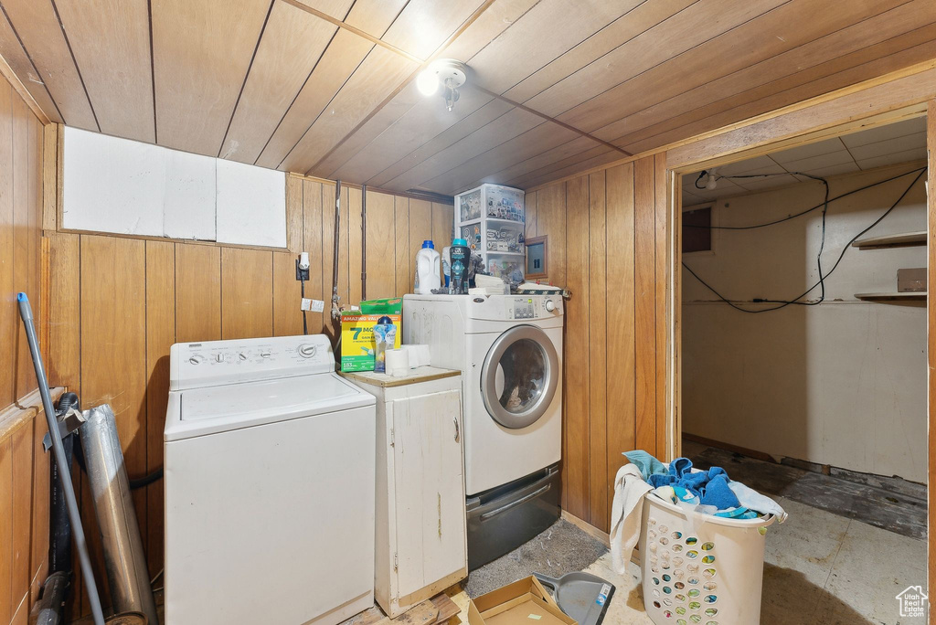Laundry room with washing machine and dryer, wooden walls, and wood ceiling