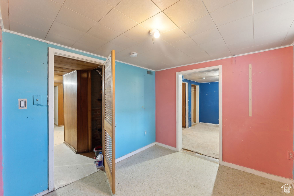 Spare room featuring baseboards, a smoke detector, and ornamental molding