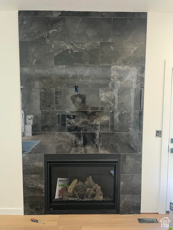 Detailed view of wood finished floors and a glass covered fireplace