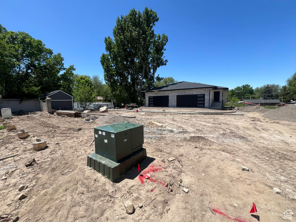 View of yard featuring a detached garage and an outbuilding
