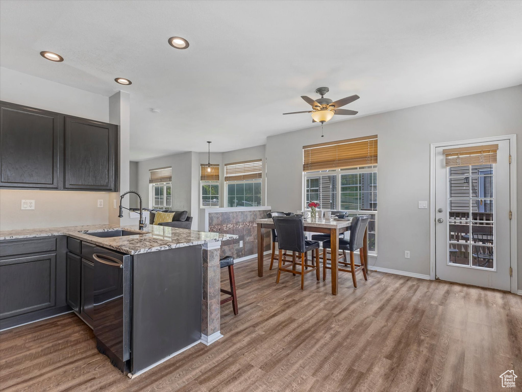 Kitchen with a sink, a ceiling fan, wood finished floors, and recessed lighting