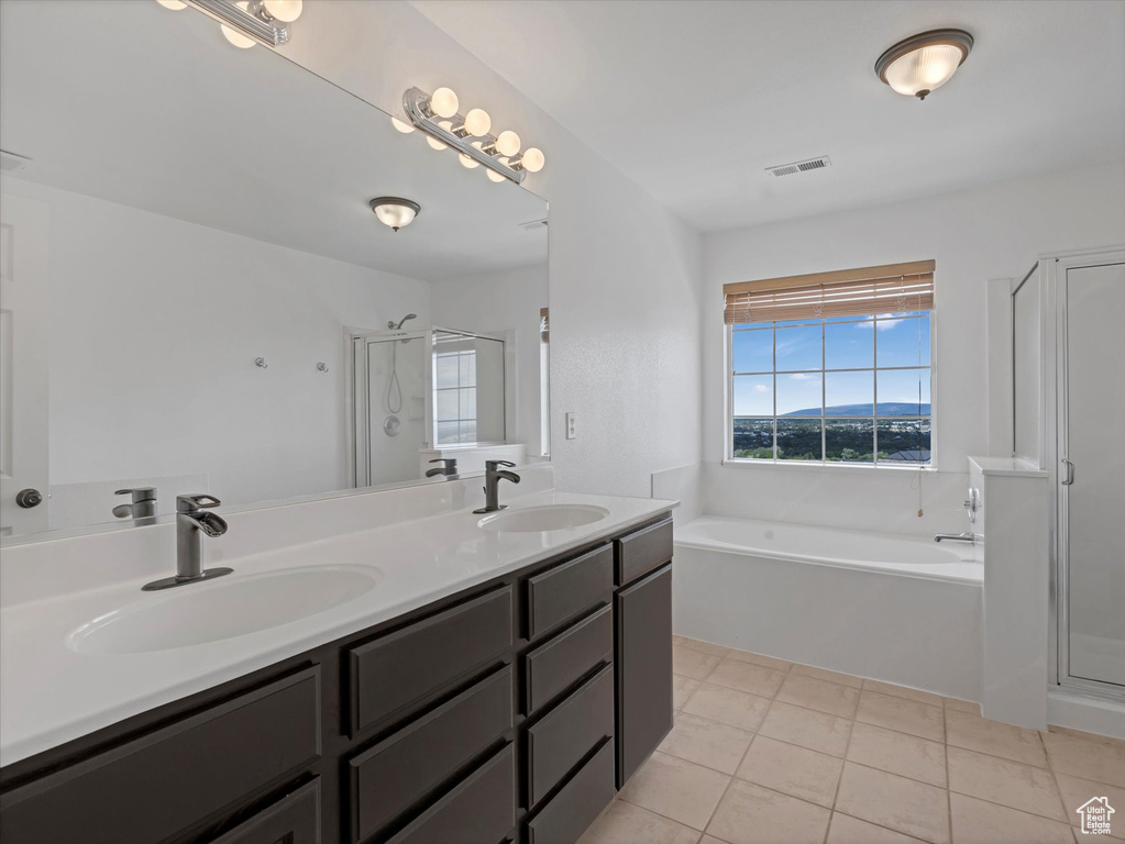 Full bath featuring a stall shower, double vanity, a bath, and tile patterned flooring