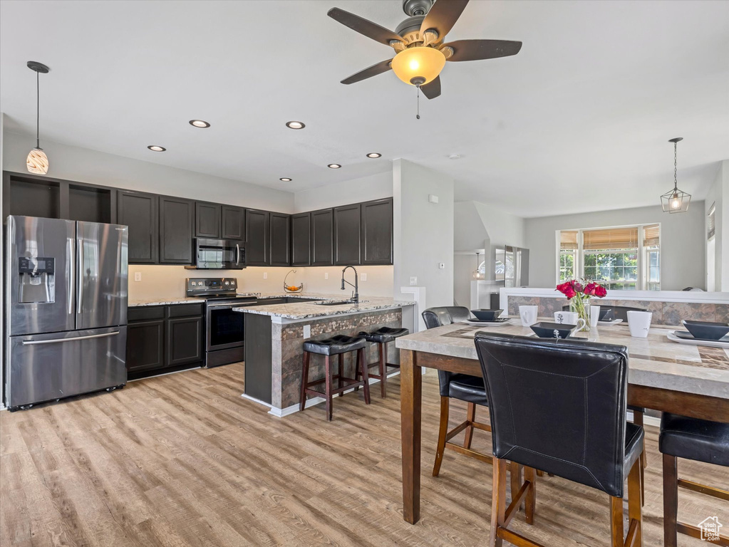 Dining room with light wood-type flooring, a ceiling fan, and recessed lighting