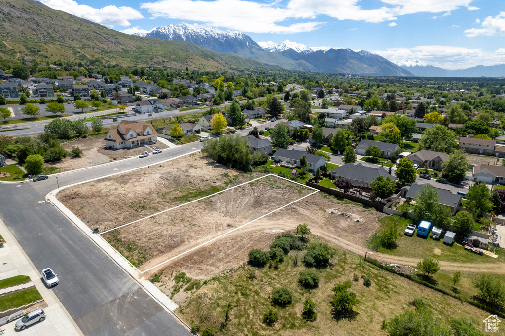 Aerial perspective of suburban area with property parcel outlined and a mountainous background