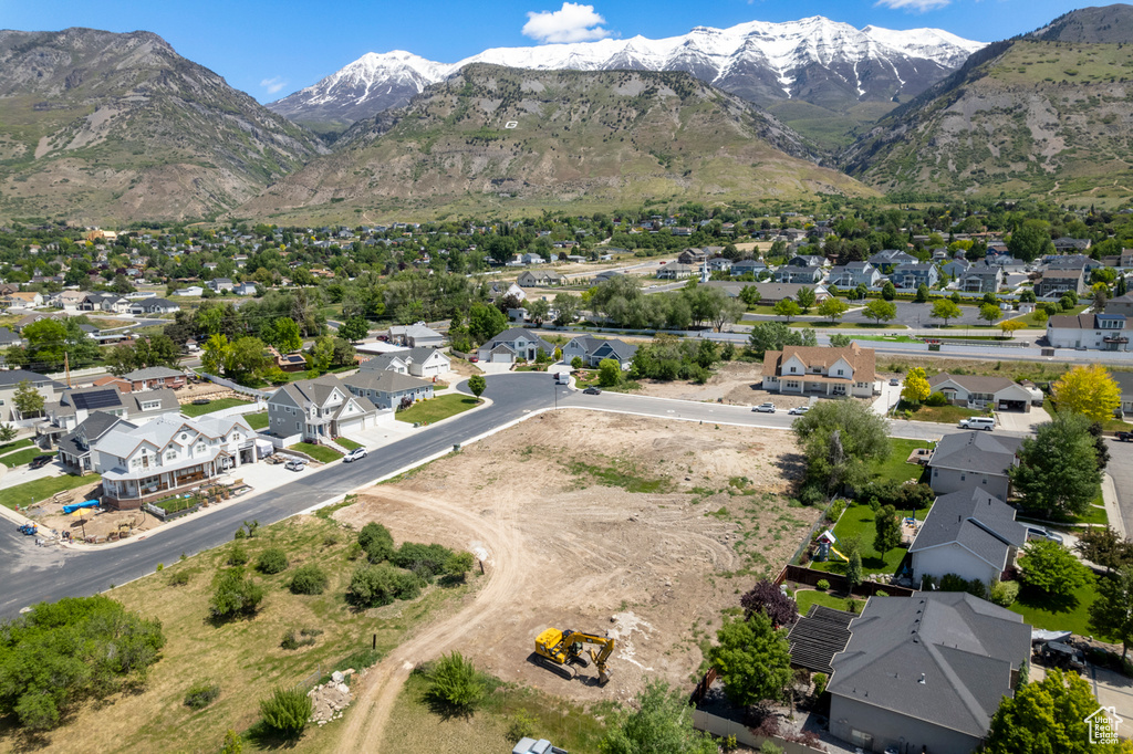 Aerial view of property and surrounding area featuring nearby suburban area and a mountain backdrop