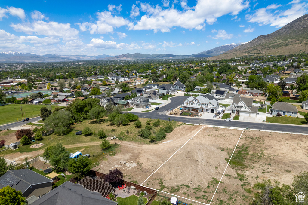 Aerial view of residential area with a mountainous background and property boundaries highlighted