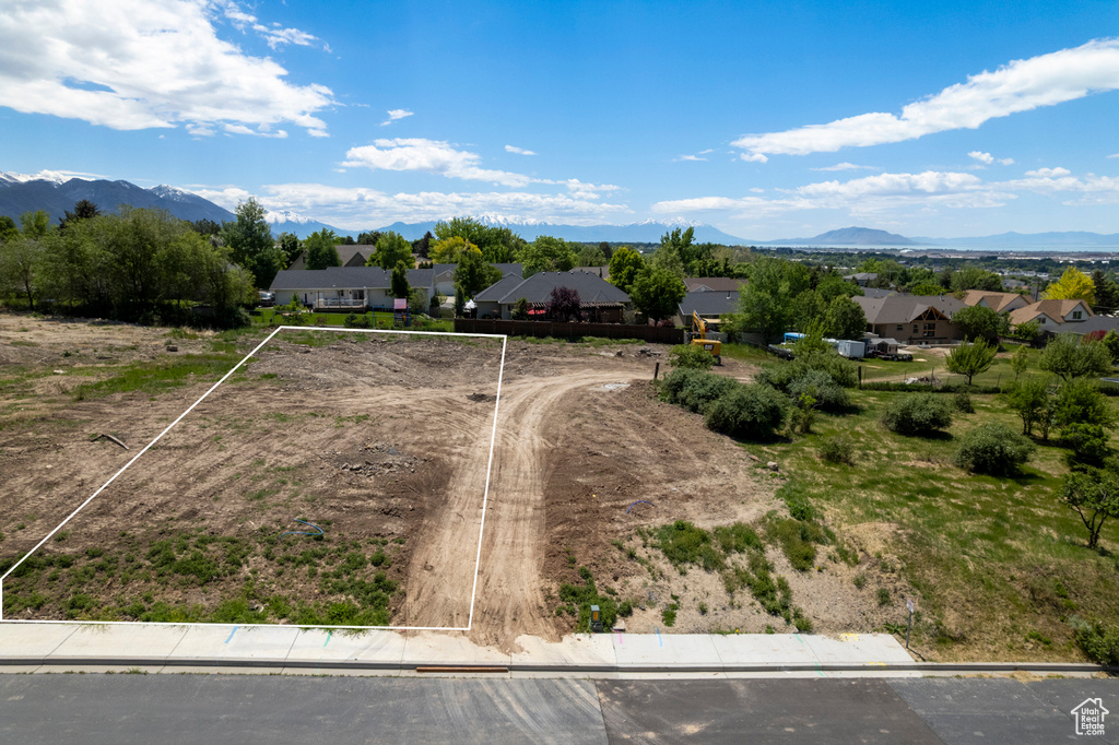 Aerial view of residential area with property parcel outlined and mountains