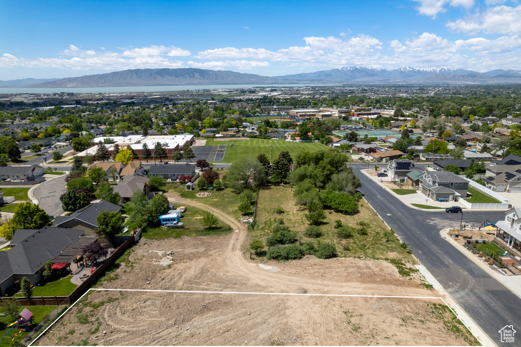 Aerial view of residential area with a mountainous background and property boundaries highlighted