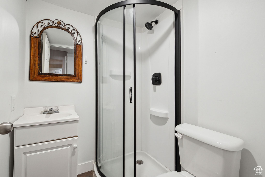 Full bathroom featuring a shower stall, vanity, and toilet