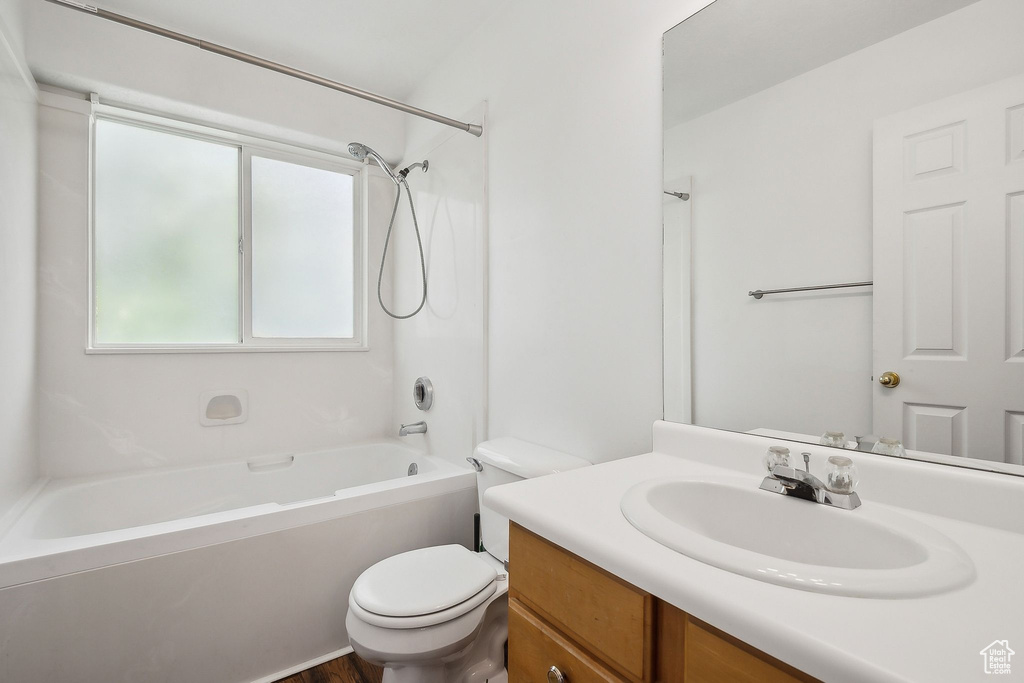 Bathroom with toilet, shower / bathtub combination, and vanity