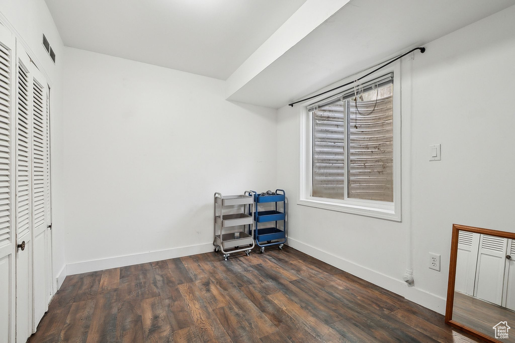 Bedroom featuring dark wood-type flooring and baseboards