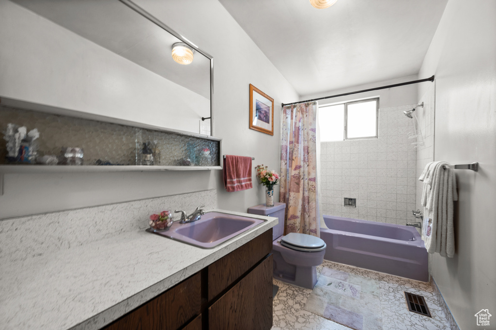 Full bathroom with toilet, shower / tub combo with curtain, and vanity