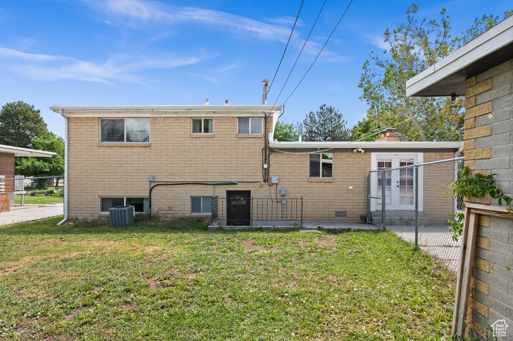 Rear view of house with french doors, brick siding, and a patio area
