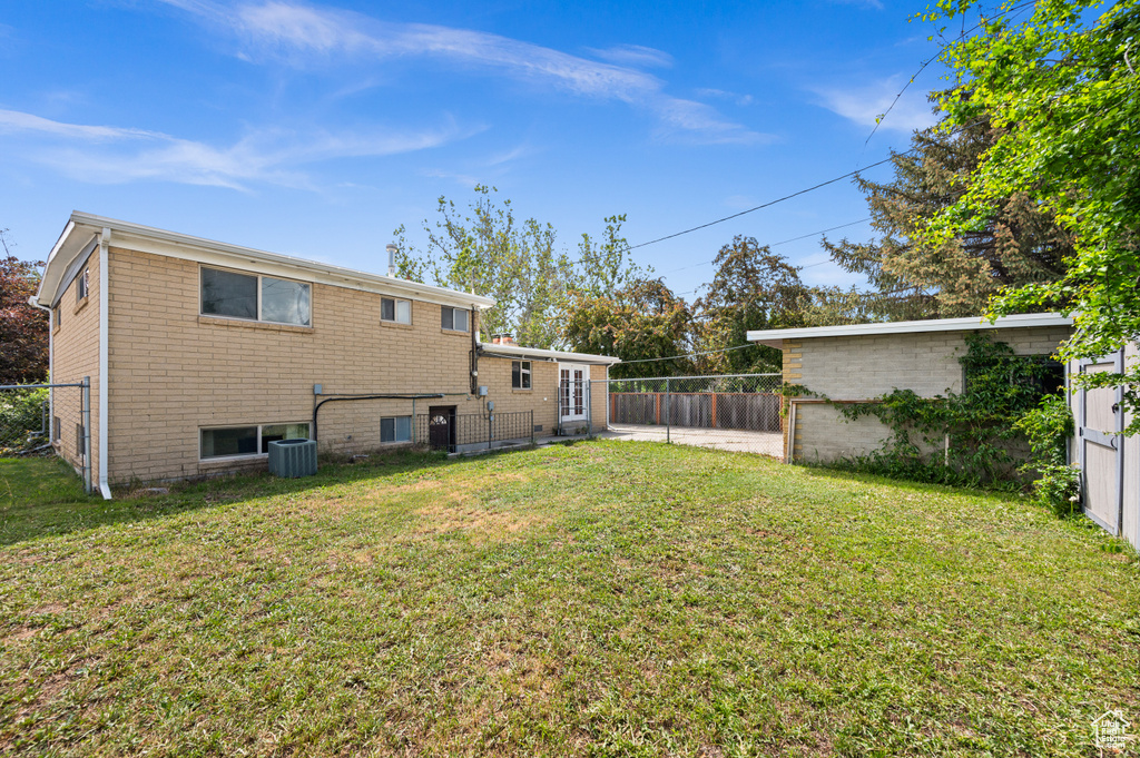 Rear view of property featuring cooling unit and brick siding