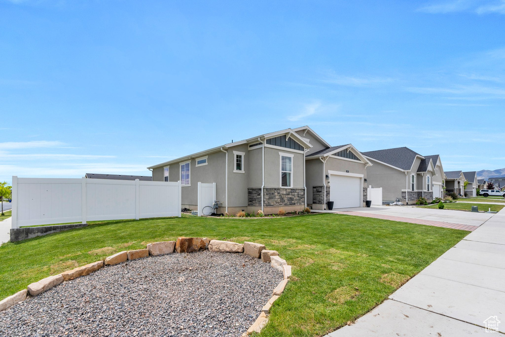 Craftsman inspired home featuring concrete driveway, stucco siding, an attached garage, a residential view, and stone siding