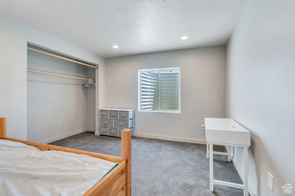 Carpeted bedroom featuring a textured ceiling, a closet, baseboards, and recessed lighting