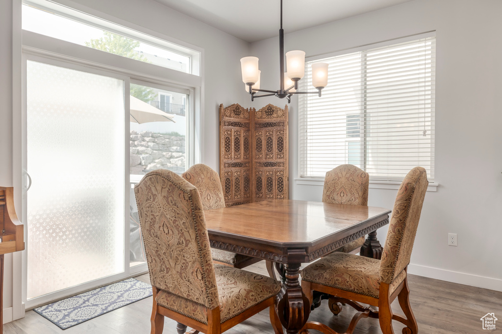 Dining space with a chandelier, light wood-style flooring, and baseboards