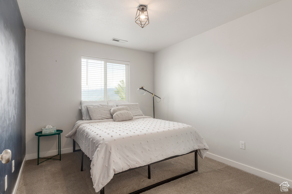 Bedroom with light carpet and baseboards