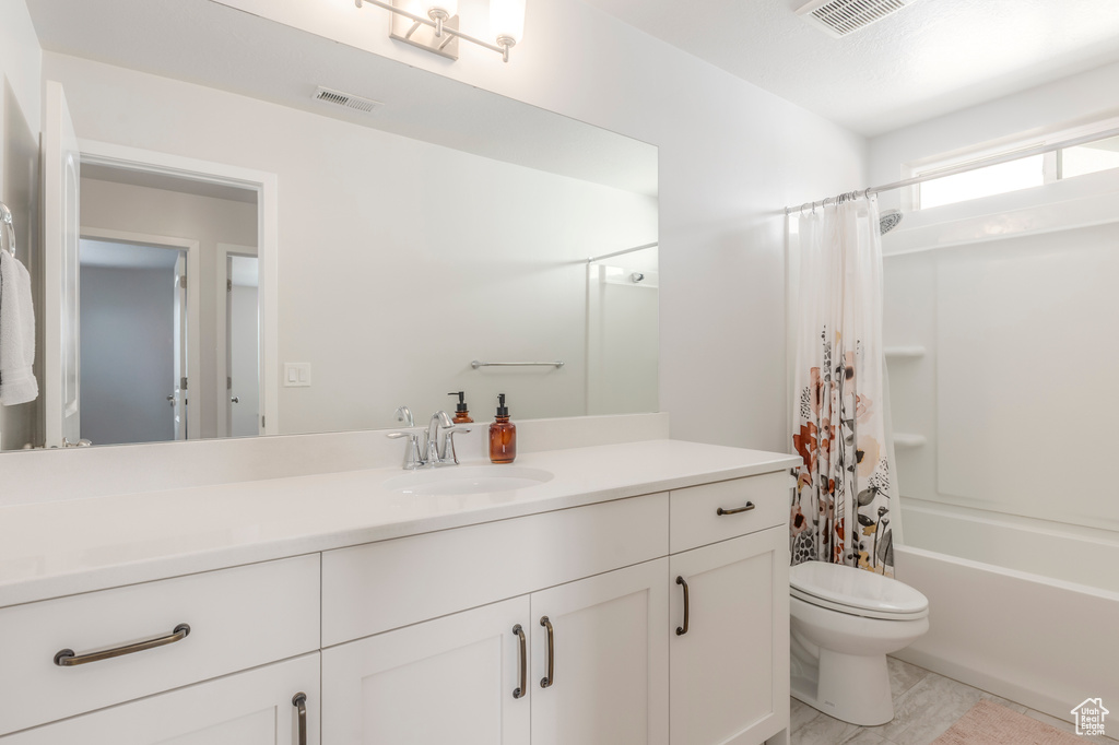 Full bath with toilet, vanity, shower / bath combo, and tile patterned flooring