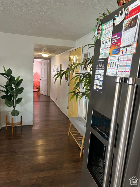 Hallway featuring a textured ceiling, wood finished floors, and baseboards