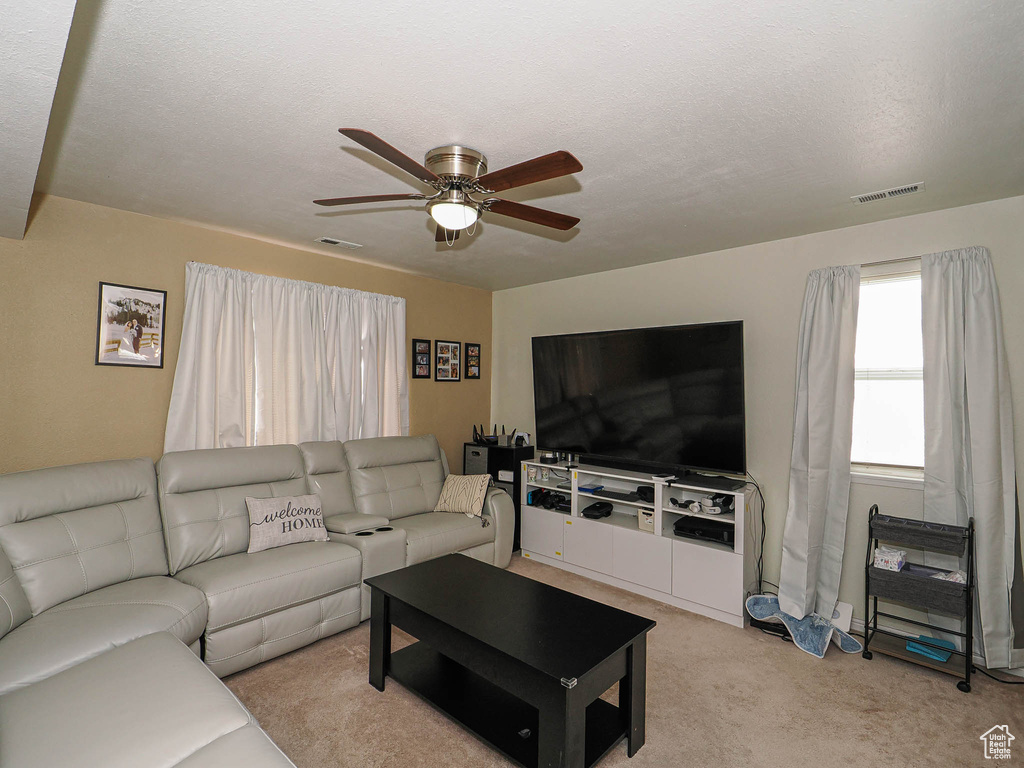 Living room with a ceiling fan and light carpet