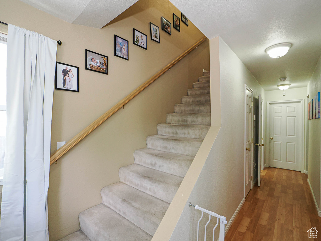 Stairway featuring wood finished floors and baseboards