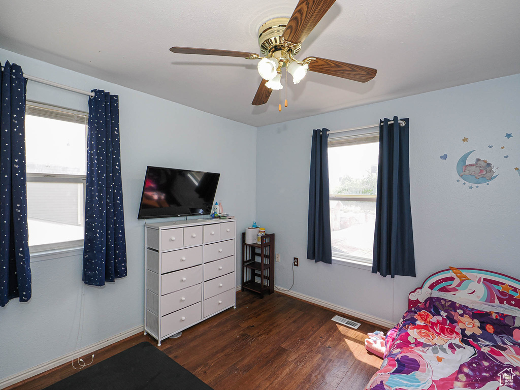 Bedroom featuring wood finished floors, a ceiling fan, and baseboards