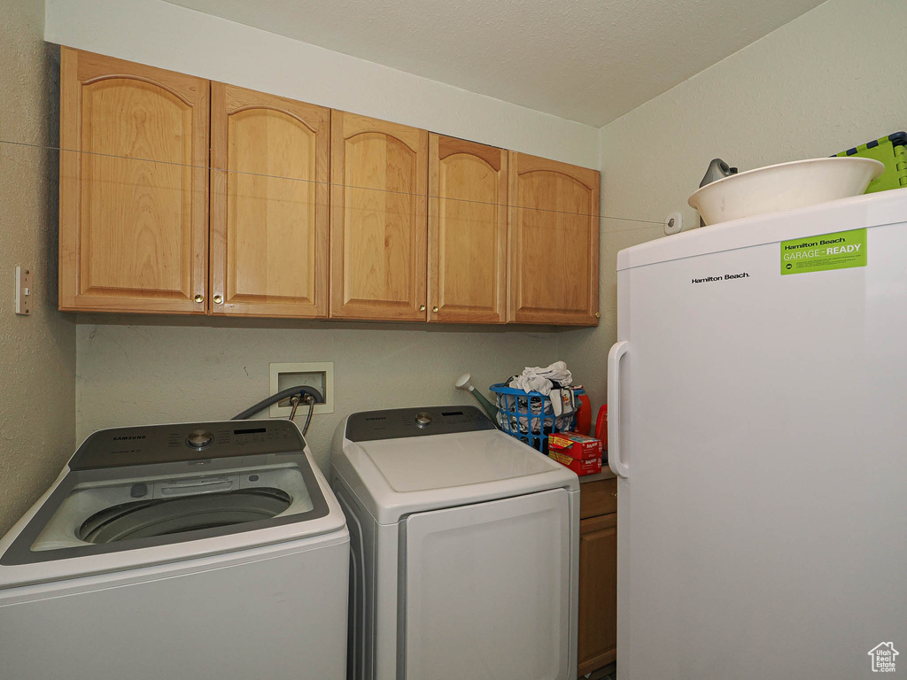 Laundry room with cabinet space and washer and clothes dryer