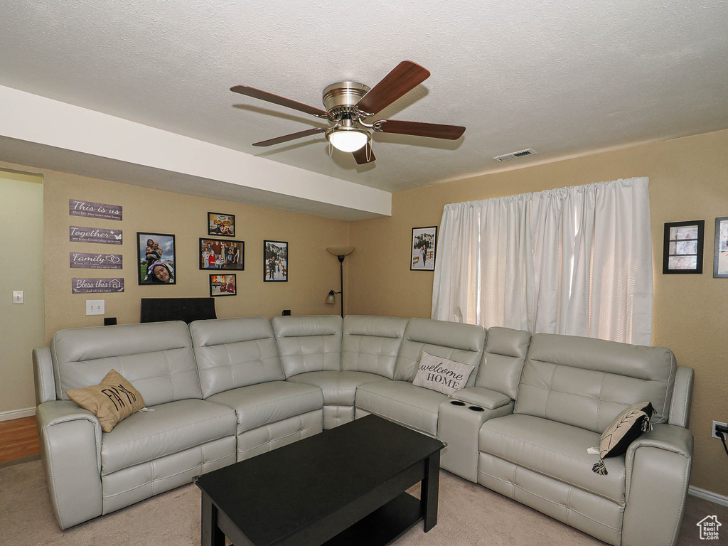 Living room featuring ceiling fan, carpet, and baseboards