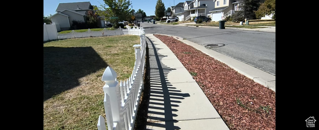 View of asphalt street with sidewalks, a residential view, and curbs