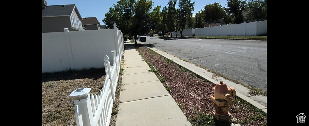 View of asphalt road featuring sidewalks