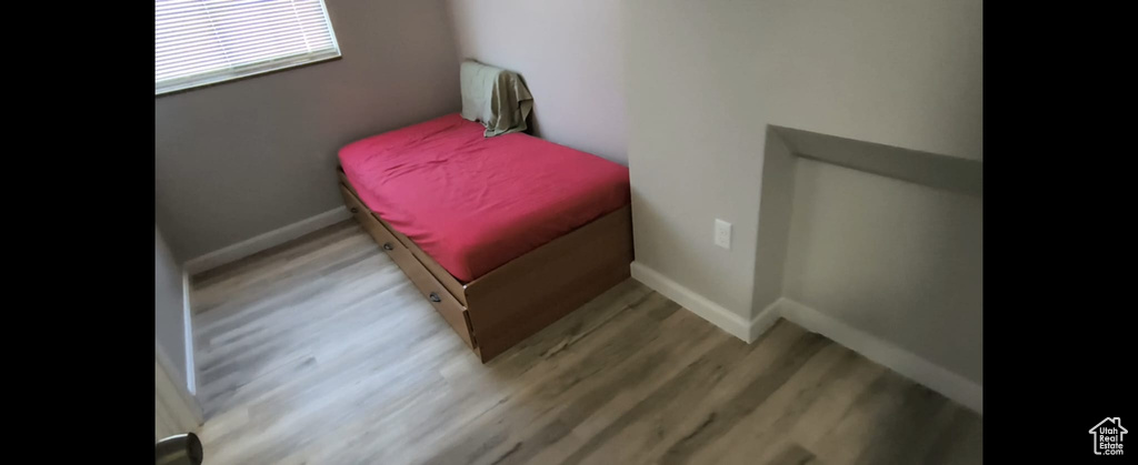 Bedroom with wood finished floors and baseboards