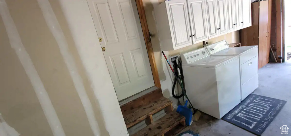 Washroom featuring separate washer and dryer and cabinet space