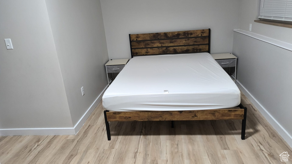 Bedroom with wood finished floors and baseboards